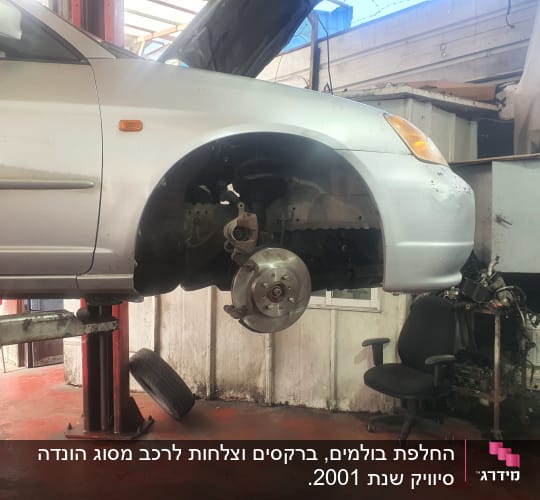 רכב מורם במוסך עם גלגל קדמי חסר